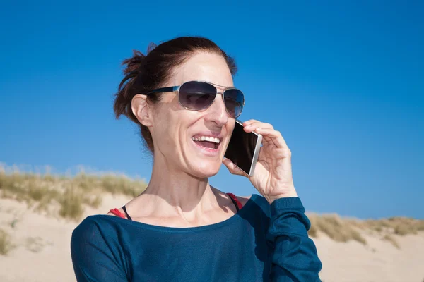 Modrý svetr žena se slunečními brýlemi na mobilní — Stock fotografie