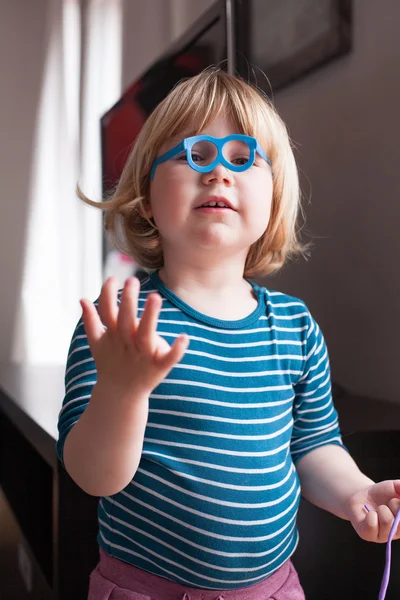 Маленький ребенок играет в игрушечные очки — стоковое фото