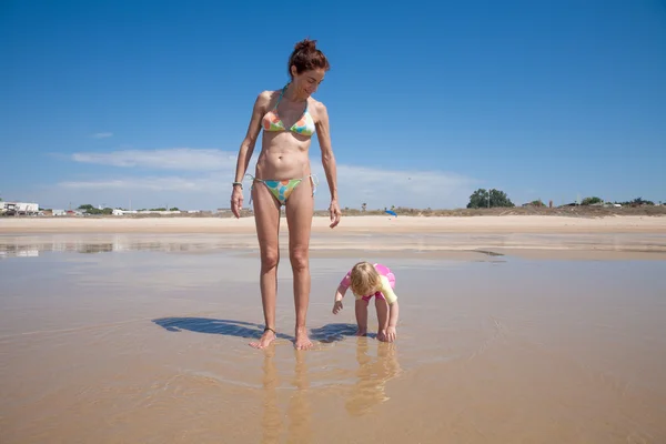 Bebé y madre en la orilla del mar — Foto de Stock