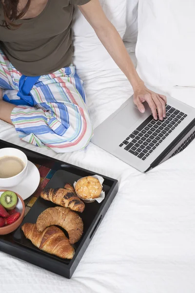 Desayuno en la cama con ordenador portátil — Foto de Stock