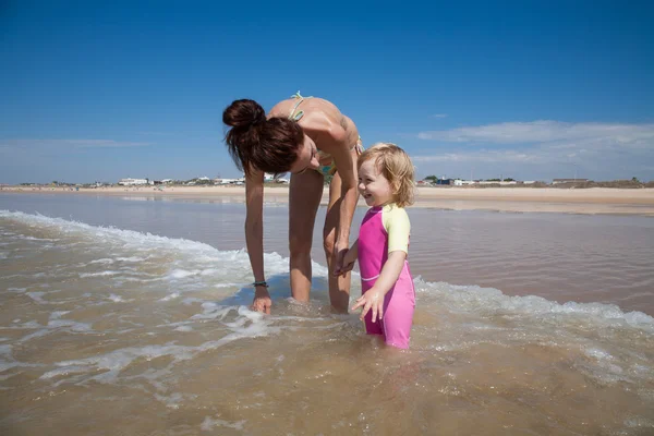 Smiling baby and mother at ocean — Stock Photo, Image