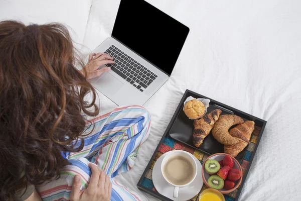 Pisania na klawiaturze laptopa i śniadanie — Zdjęcie stockowe