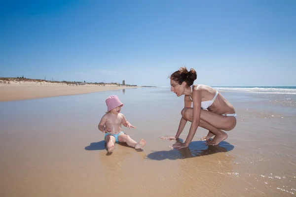 Mujer y bebé en la orilla del mar — Foto de Stock