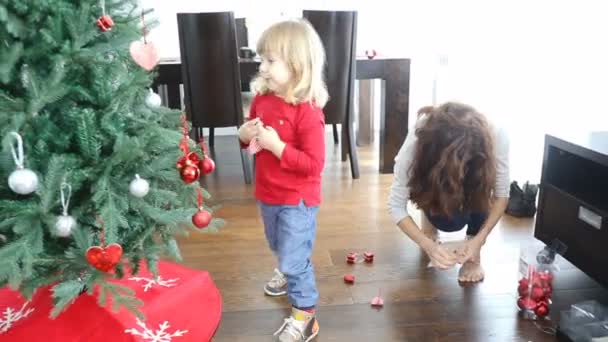 Moeder en kind versieren kerstboom — Stockvideo