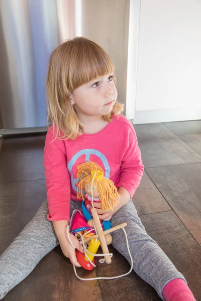 床に座って人形と金髪の子 — ストック写真