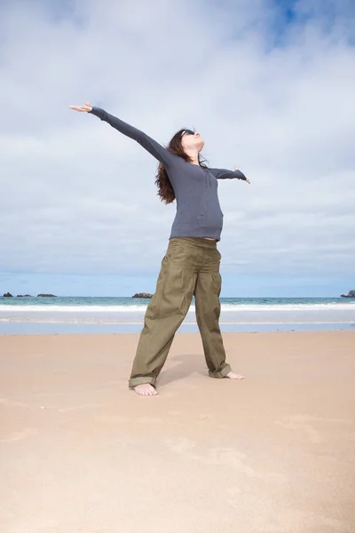 Öppna armar glad gravid på stranden — Stockfoto