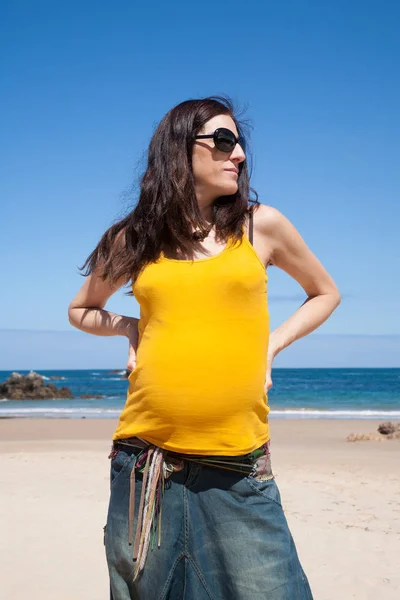 Żółta Koszulka w ciąży kobieta na plaży — Zdjęcie stockowe