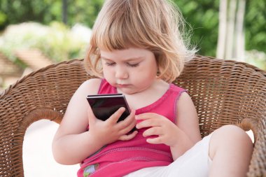 sandalye izlerken küçük çocuk cep telefonu konsantre