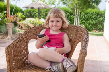 Telefon görünümlü gülümseyen sandalye üzerinde küçük çocuk