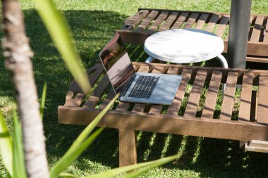 Açık dış ahşap şezlong üstünde laptop