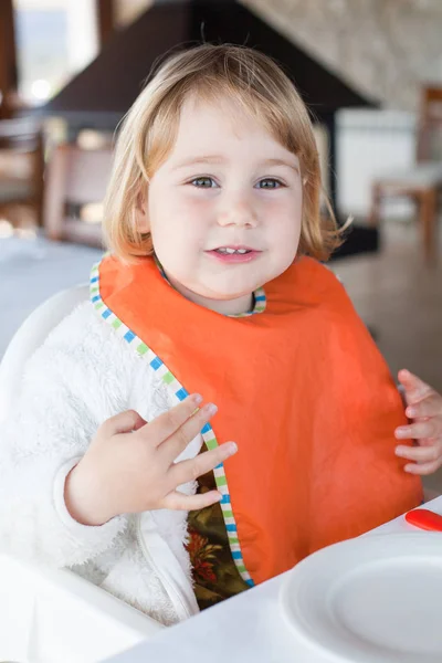 Bebê bonito babete laranja comer — Fotografia de Stock