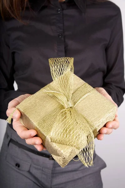 Golden present on businesswoman hands — Stock Photo, Image