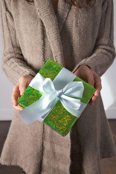 Presente verde em mãos de mulher de inverno — Fotografia de Stock