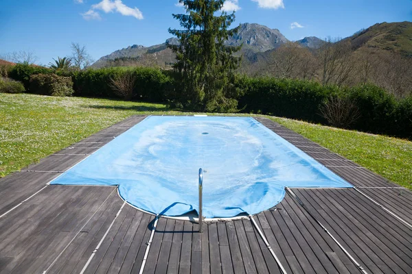 Bazén uzavřen s modrou plachtu — Stock fotografie