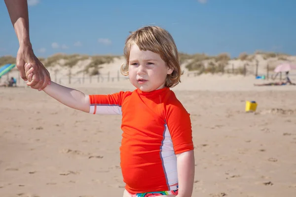 Niño pequeño cogido de la mano de mujer en la playa — Foto de Stock