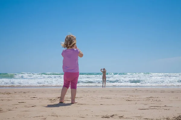 Mother at sea shore calling little girl at beach — Stock Photo, Image