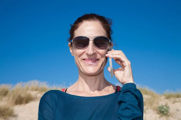 Retrato suéter azul mujer con gafas de sol hablando en el móvil —  Fotos de Stock