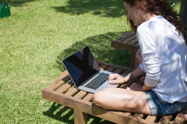 Kobieta za pomocą pusty ekran laptopa w ogrodzie — Zdjęcie stockowe