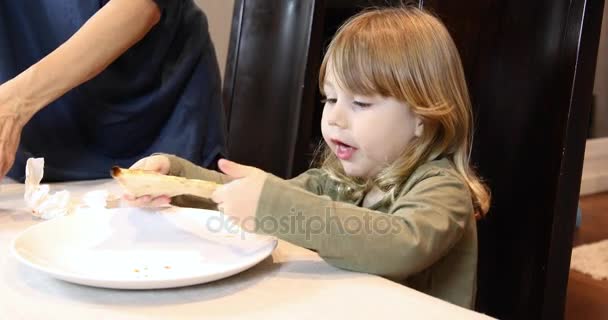 Niño come pizza de lado — Vídeo de stock