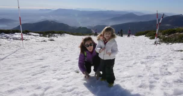 Niño con madre lanzando una bola de nieve — Vídeo de stock