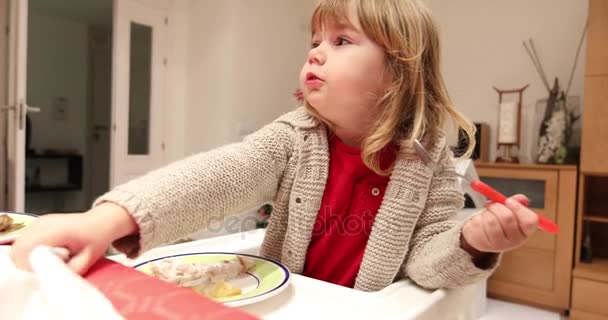 Little child in high chair eating fish with hand — Stock Video