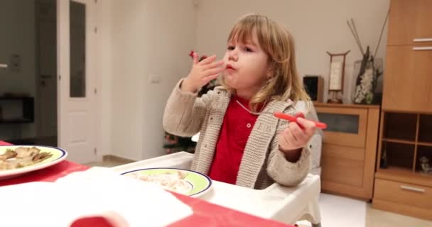 Klein kind in de kinderstoel, eten van vis — Stockvideo