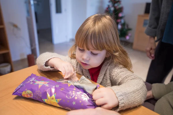 Child opening Christmas present wrapped in paper — Stock Photo, Image