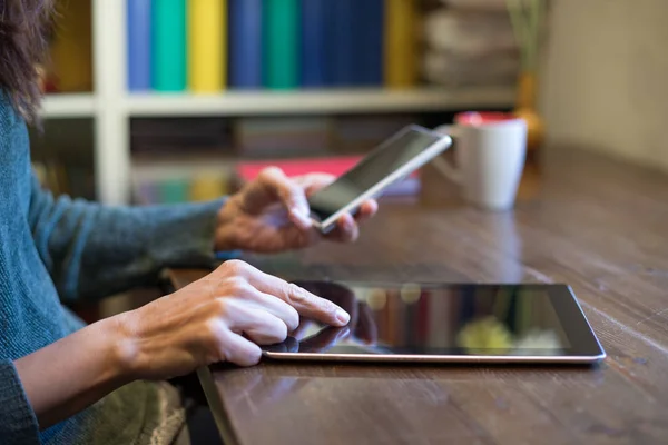 Mãos de mulher usando tablet e smartphone — Fotografia de Stock