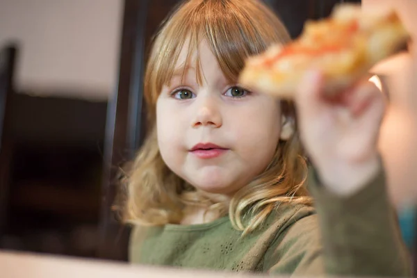 Pequena criança oferecendo pedaço de pizza — Fotografia de Stock