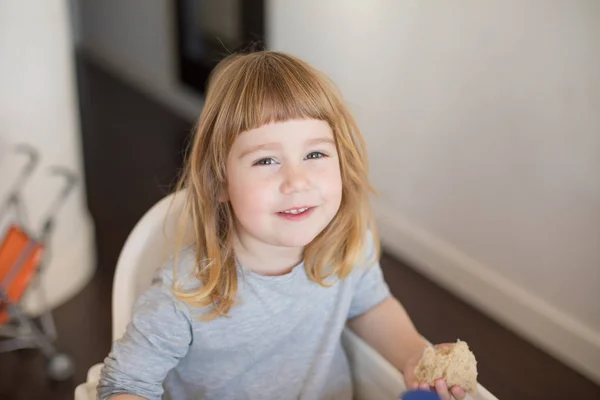 Retrato de criança olhando e comendo pão — Fotografia de Stock