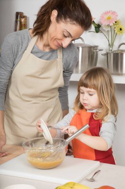 Çocuk dökme rendelenmiş limon kabuğu annesi yanındaki kapta