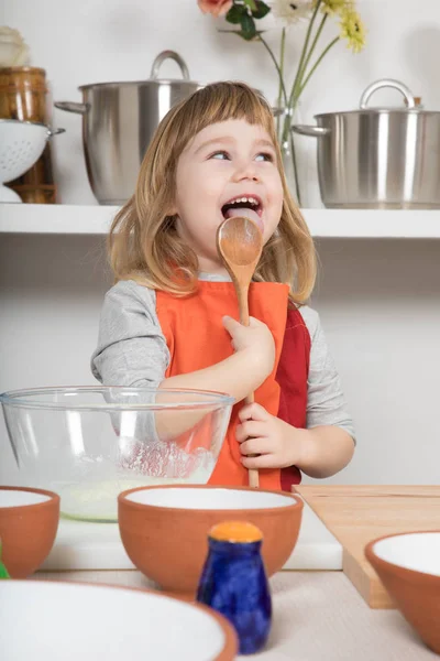 Lustiges Kind kocht Kochlöffel lecken — Stockfoto