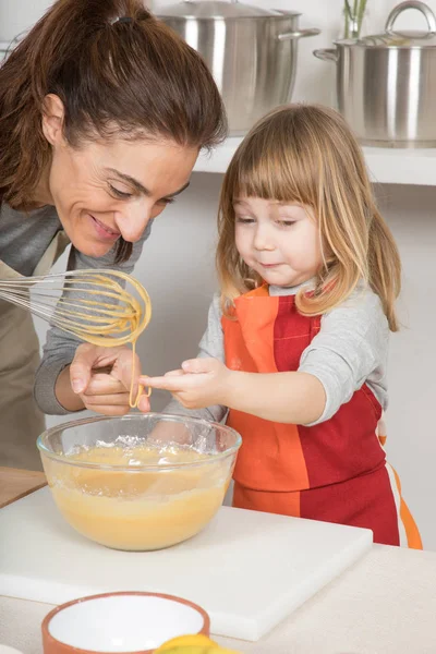 Lustige Mutter und Kind berühren Schlagsahne mit dem Finger — Stockfoto