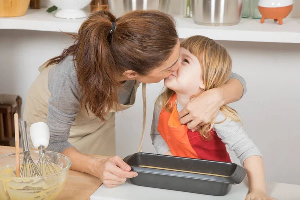 Mutter küsst Kind zum Kuchenbacken — Stockfoto
