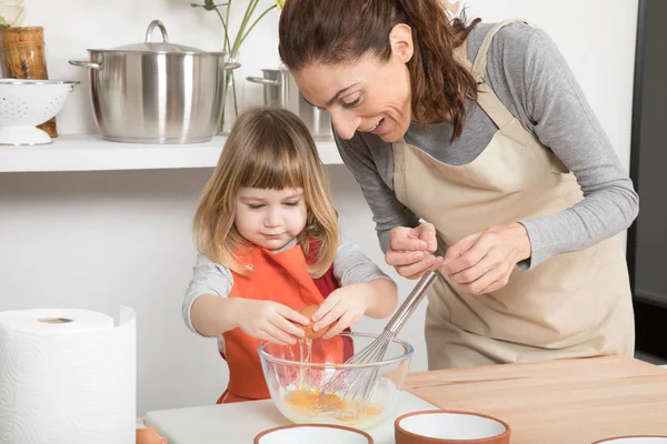 Frau und Kind kochen ein Ei in Schüssel — Stockfoto