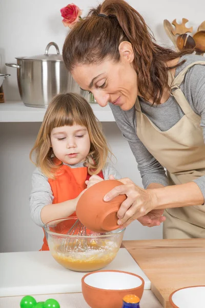 Frau schüttet Mehl in Schüssel und schlägt Kind — Stockfoto