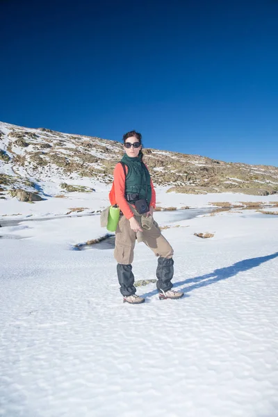 Треккинг женщина, стоящая в зимнем снегу — стоковое фото