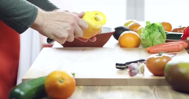 Hands of man peeling apple on wooden cutting board — Stock Video