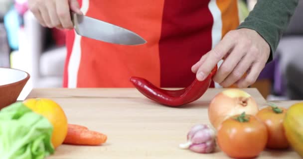 Man skär röd paprika på trä skärbräda — Stockvideo