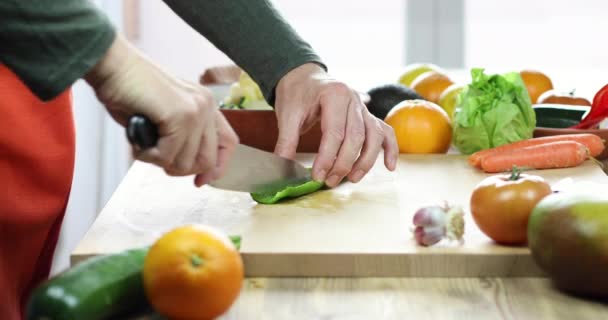 Man hands cutting green pepper on wooden cutting board — Stock Video