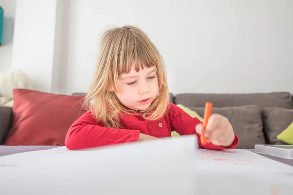 Blonde child drawing on white paper — Stock Photo, Image