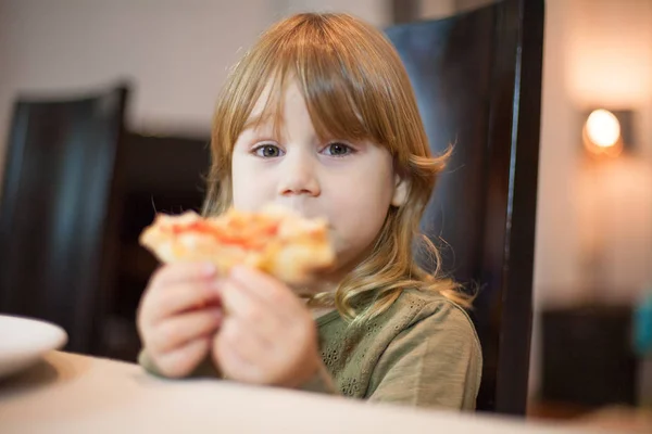 Маленька дитина показує шматочок піци — стокове фото