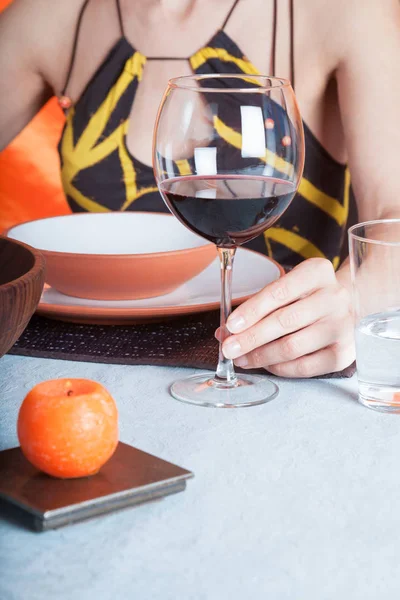 Woman hand with cup of wine on blue tablecloth — Stock Photo, Image