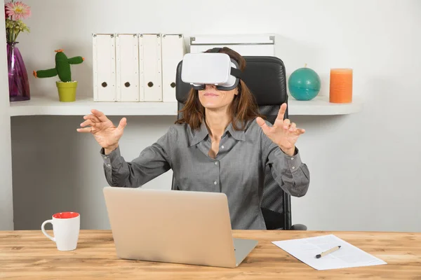 Businesswoman with virtual reality headset and laptop in workpla — Stock Photo, Image