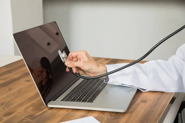 Hand of doctor woman auscultating computer — Stock Photo, Image