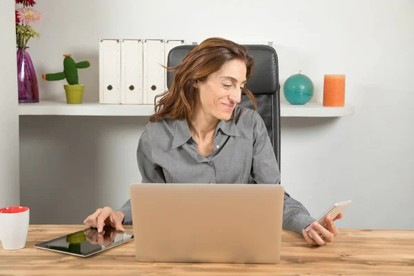 Multitasking donna d'affari con tablet telefono e computer — Foto Stock