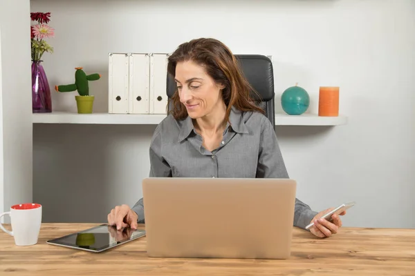 Mujer de negocios multitarea con teléfono tableta y portátil —  Fotos de Stock