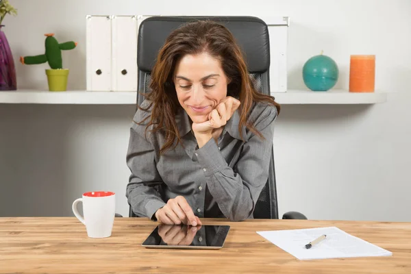 Lächelnde Geschäftsfrau liest Tablet — Stockfoto