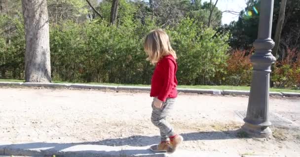Kind op de stoep in park langzaam lopen — Stockvideo