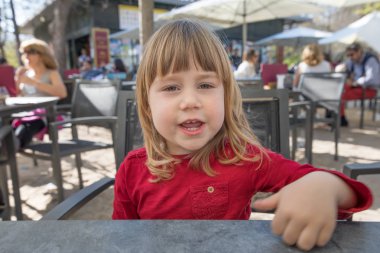 çocuk terasta otururken konuşurken size bakıyor